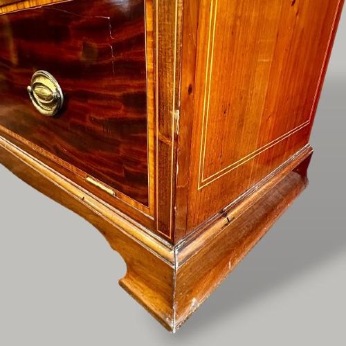 An Edwardian period Sheraton Revival mahogany tall chest featuring flame mahogany drawer fronts with inlay stringing and brass handles. View IV