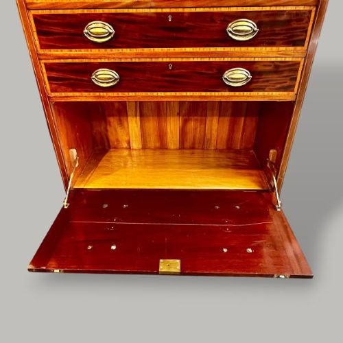 An Edwardian period Sheraton Revival mahogany tall chest featuring flame mahogany drawer fronts with inlay stringing and brass handles. View V