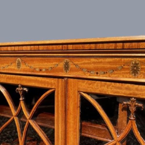 A late Victorian satinwood collectors cabinet featuring marquetry inlay details, Gothic style glazed double doors, and interior drawers. View III