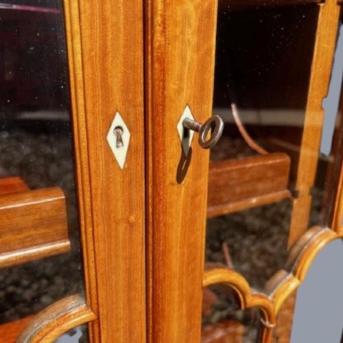 A late Victorian satinwood collectors cabinet featuring marquetry inlay details, Gothic style glazed double doors, and interior drawers. View IV