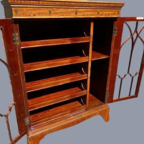 A late Victorian satinwood collectors cabinet featuring marquetry inlay details, Gothic style glazed double doors, and interior drawers. View V