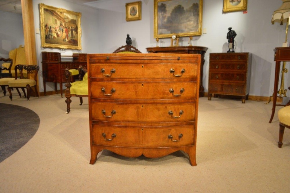 A beautiful Edwardian Period mahogany bow front chest of drawers with brushing slide