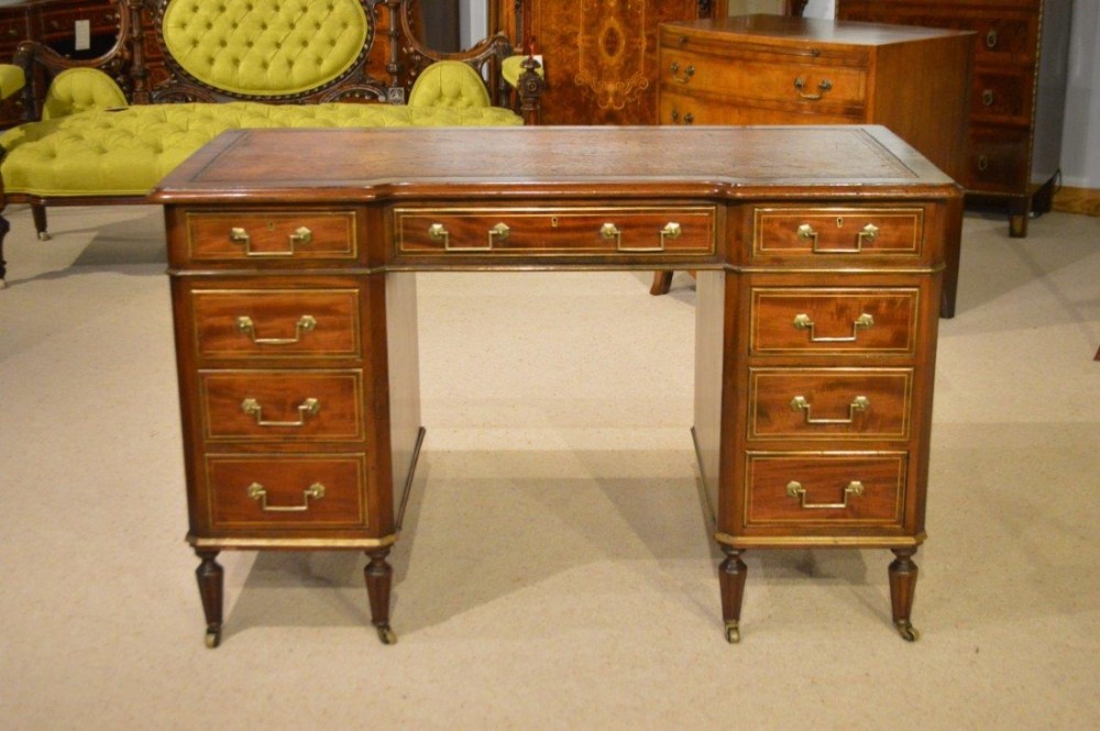 A mahogany and brass mounted Late Victorian Period pedestal desk by Bertram & Sons, Oxford Street, London.