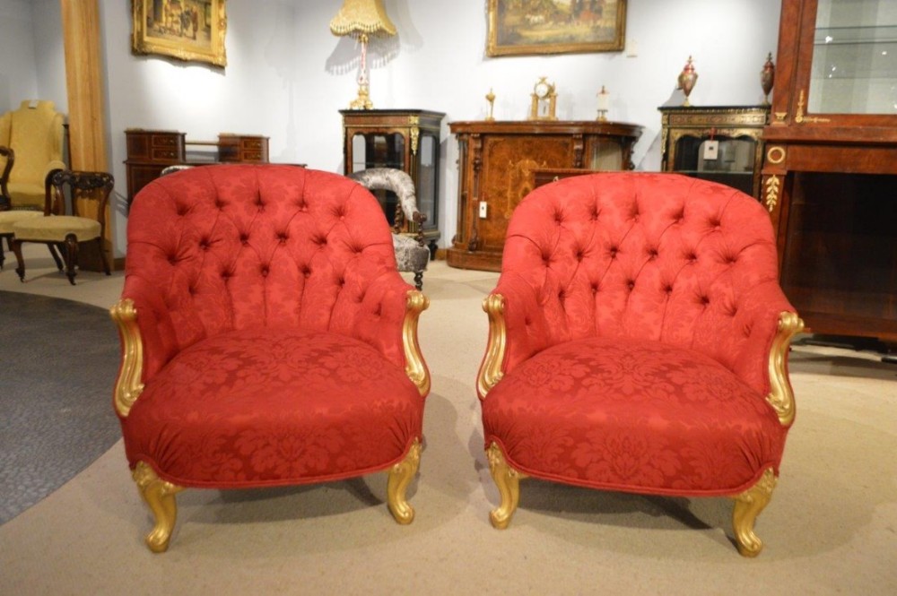 A fabulous pair of carved gilt-wood Victorian Period deep buttoned armchairs