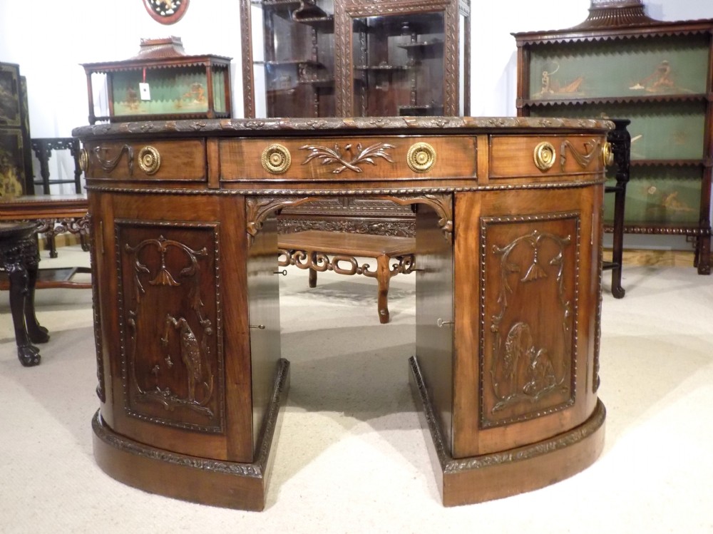 A stunning quality mahogany Late Victorian Period Chippendale designed oval partners desk.