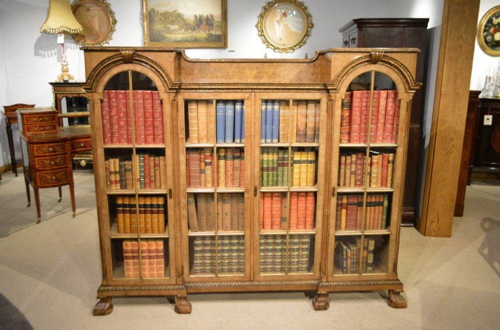 A walnut, parcel gilt and herring bone banded Queen Anne Revival antique bookcase.