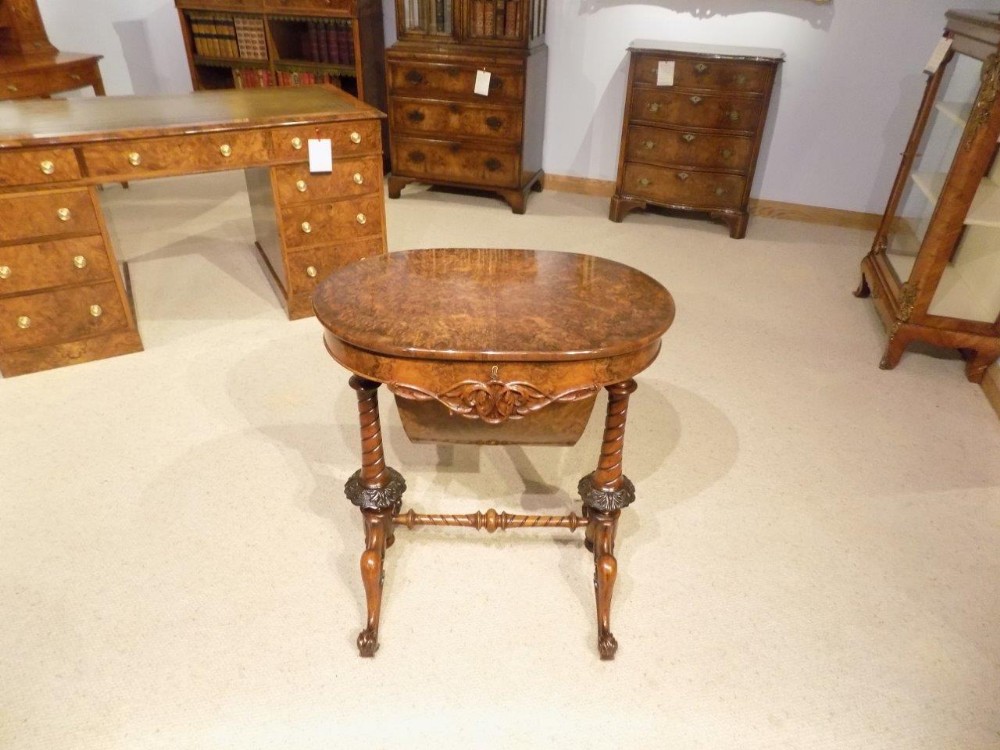 A superb Quality burr walnut Victorian Period oval shaped antique sewing table.