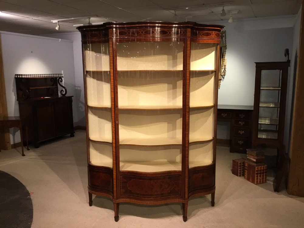 A Fine Quality mahogany inlaid Edwardian Period serpentine display cabinet by Maple & Co