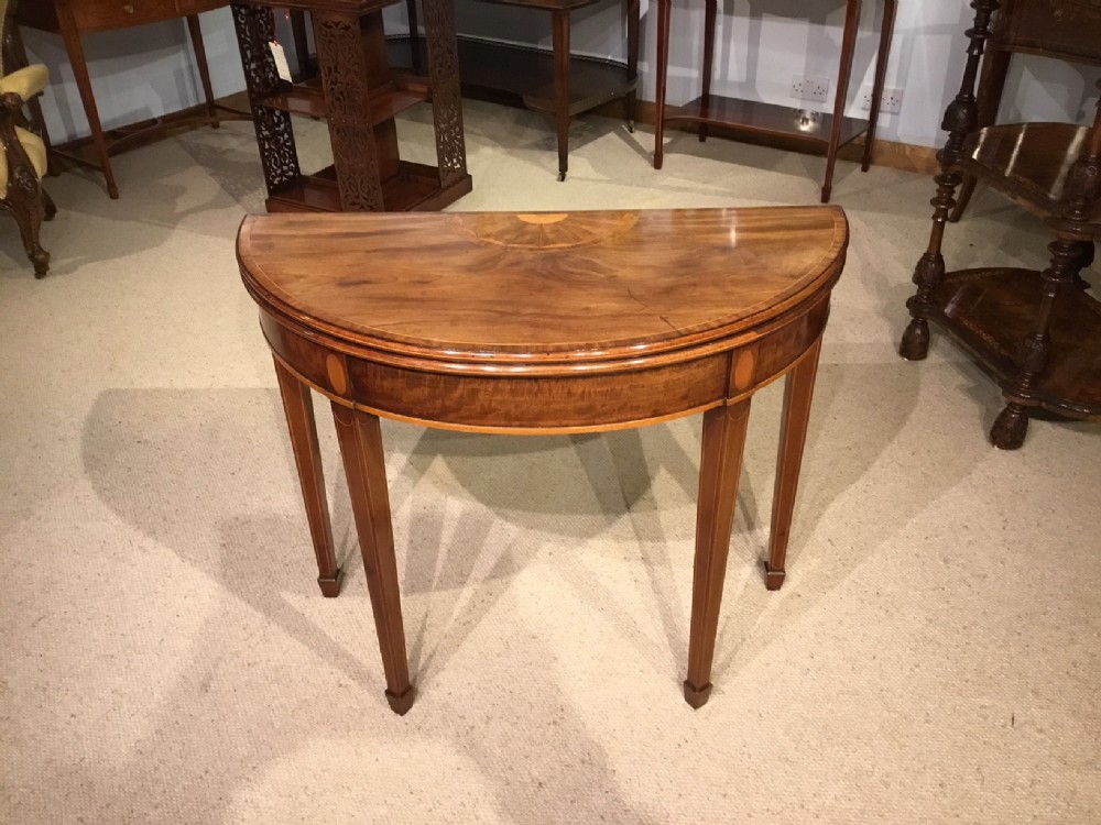 A good mahogany George III Period demi lune card table