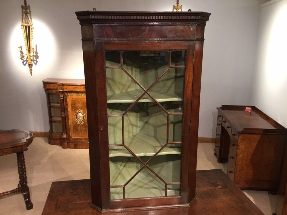 A mahogany George III Period astragal glazed hanging corner cabinet