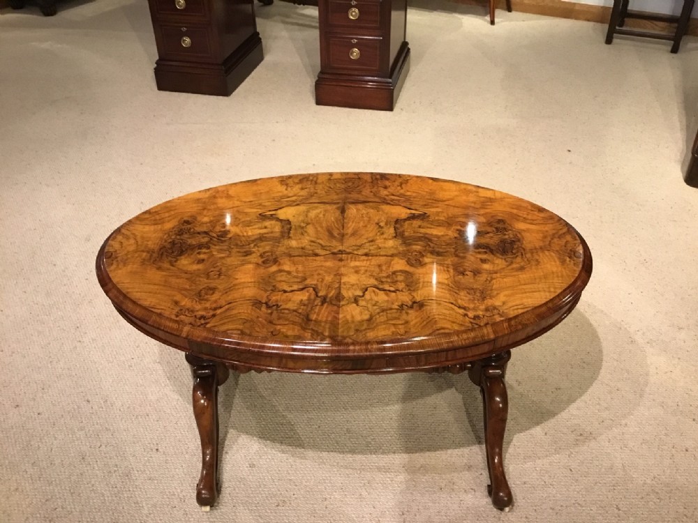 An unusual burr walnut and walnut Victorian Period oval coffee table with slide