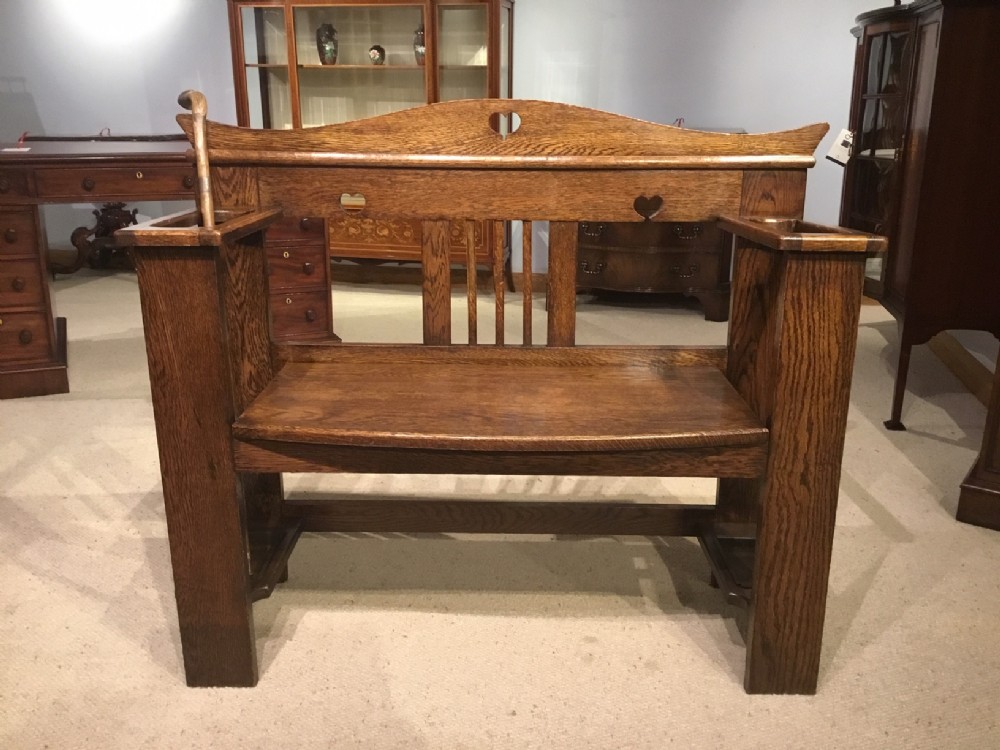 An oak Arts & Crafts Period hall bench/umbrella stick stand.