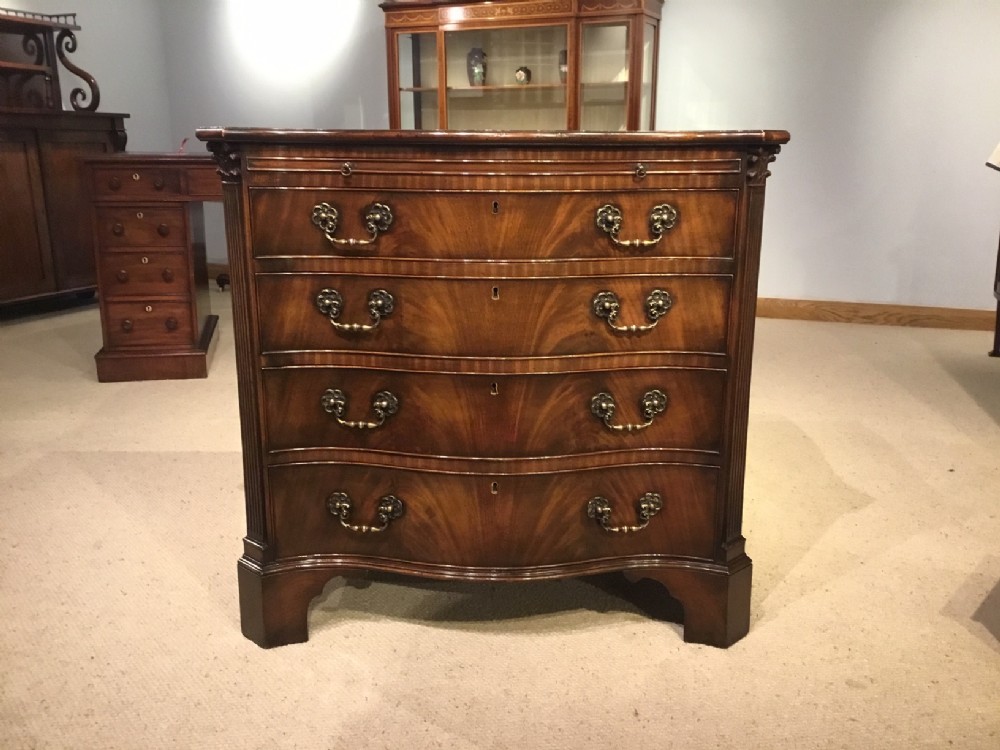 A superb quality Chippendale Revival flame mahogany serpentine bachelors chest.