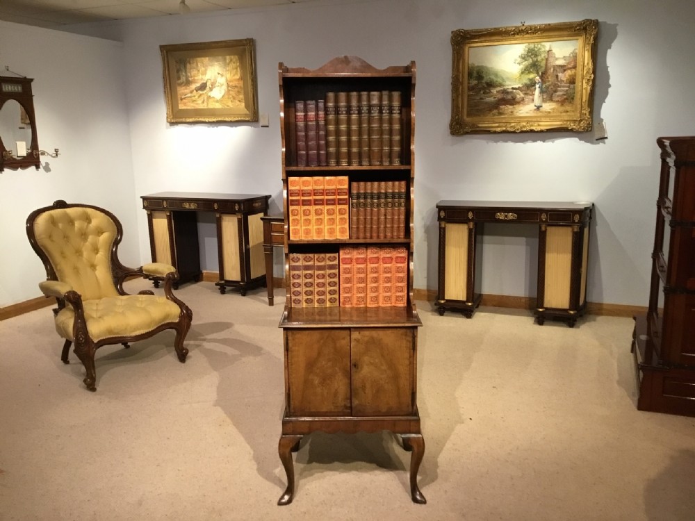A 1920s walnut Queen Anne Revival waterfall bookcase on cupboard