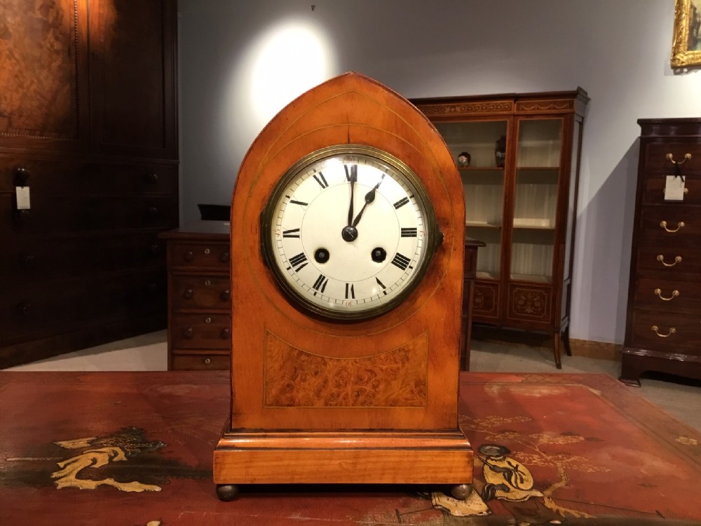 A satinwood Edwardian Period lancet shaped mantle clock