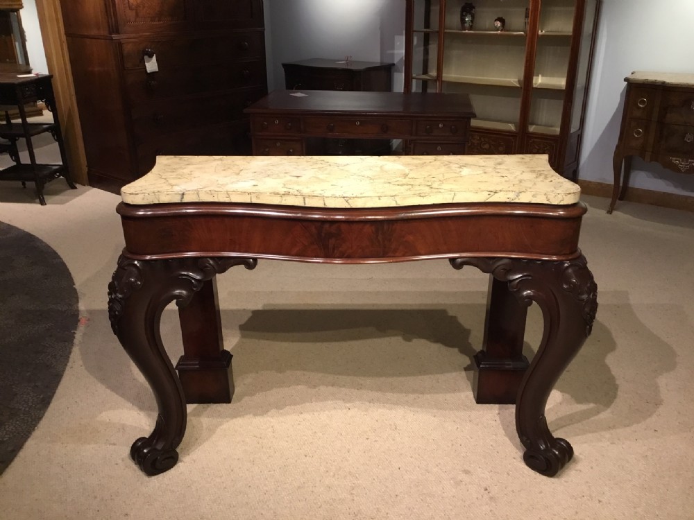 A Victorian Period mahogany serpentine console table.