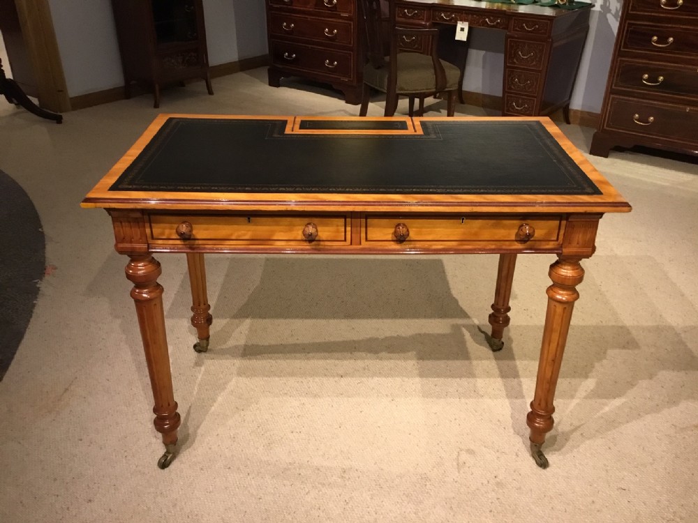 A satinwood and purple heart Victorian Period writing table by Gillows Of Lancaster. 