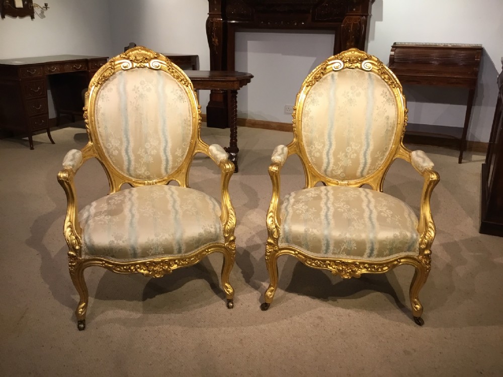 A pair of 19th Century carved and gilded fauteuils