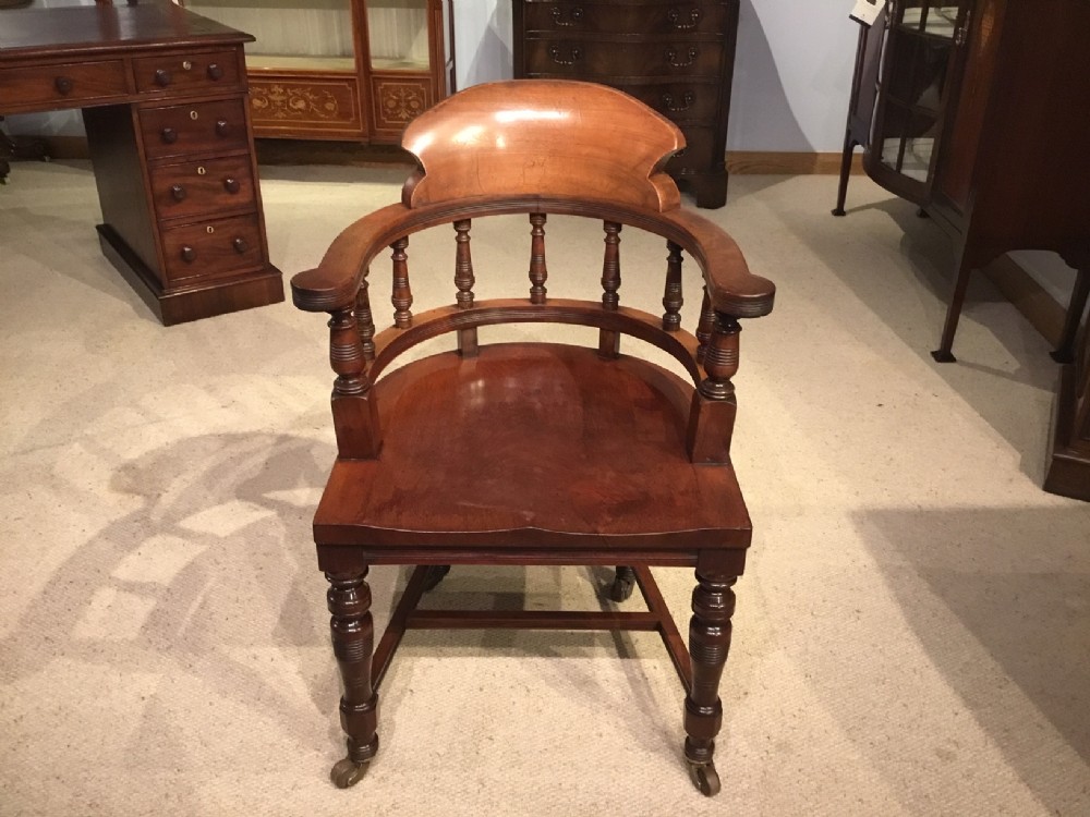 A Late Victorian Period mahogany desk armchair.