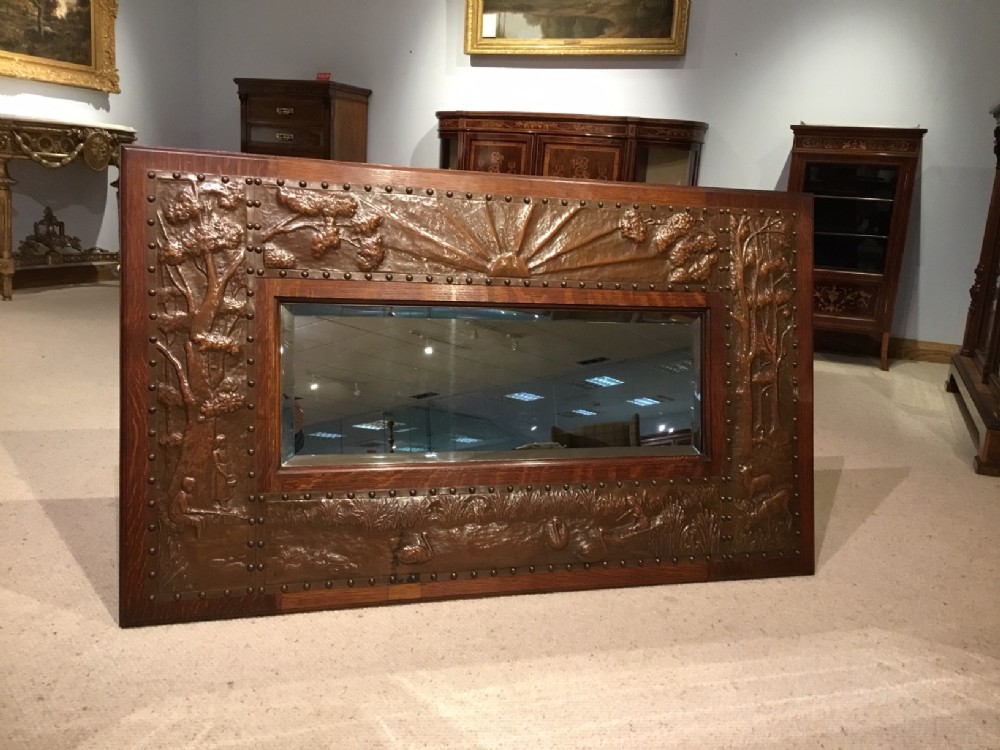 A Fine Arts and Crafts Period oak and copper mirror