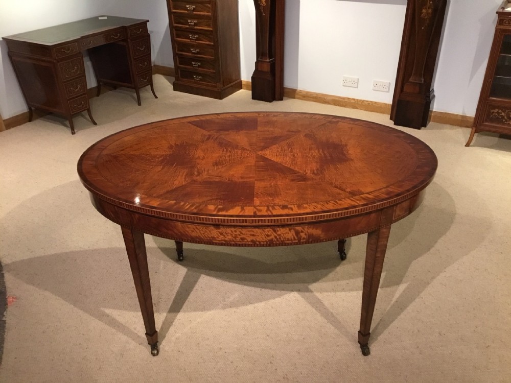 A fine quality figured satinwood Sheraton Revival oval centre table.