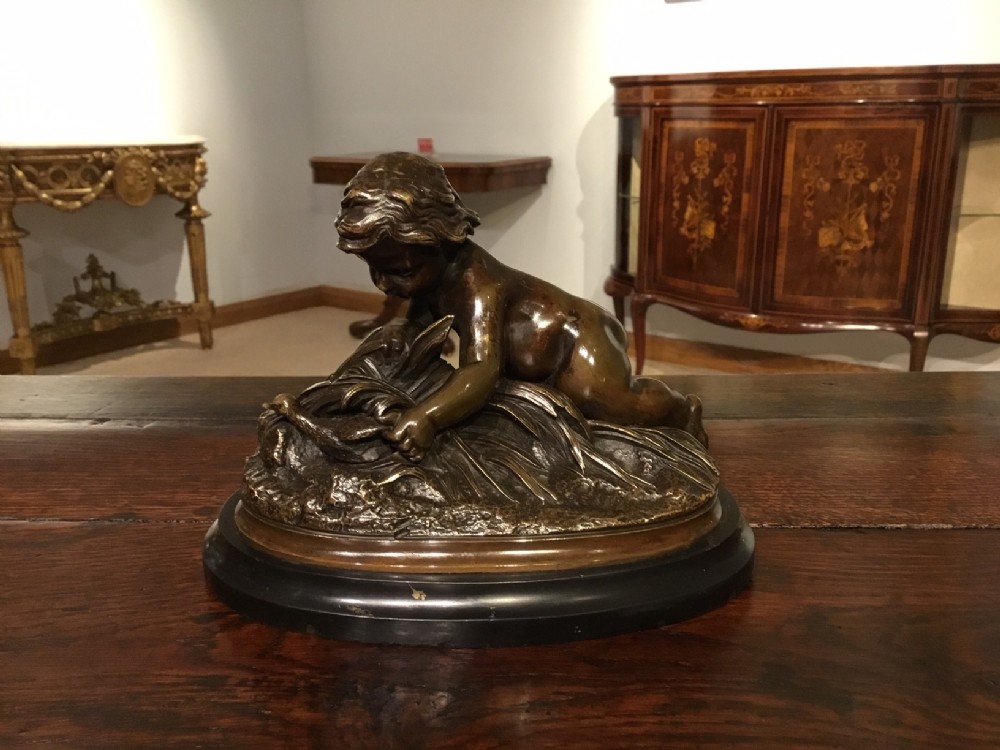 A charming French bronze group depicting a cherub
