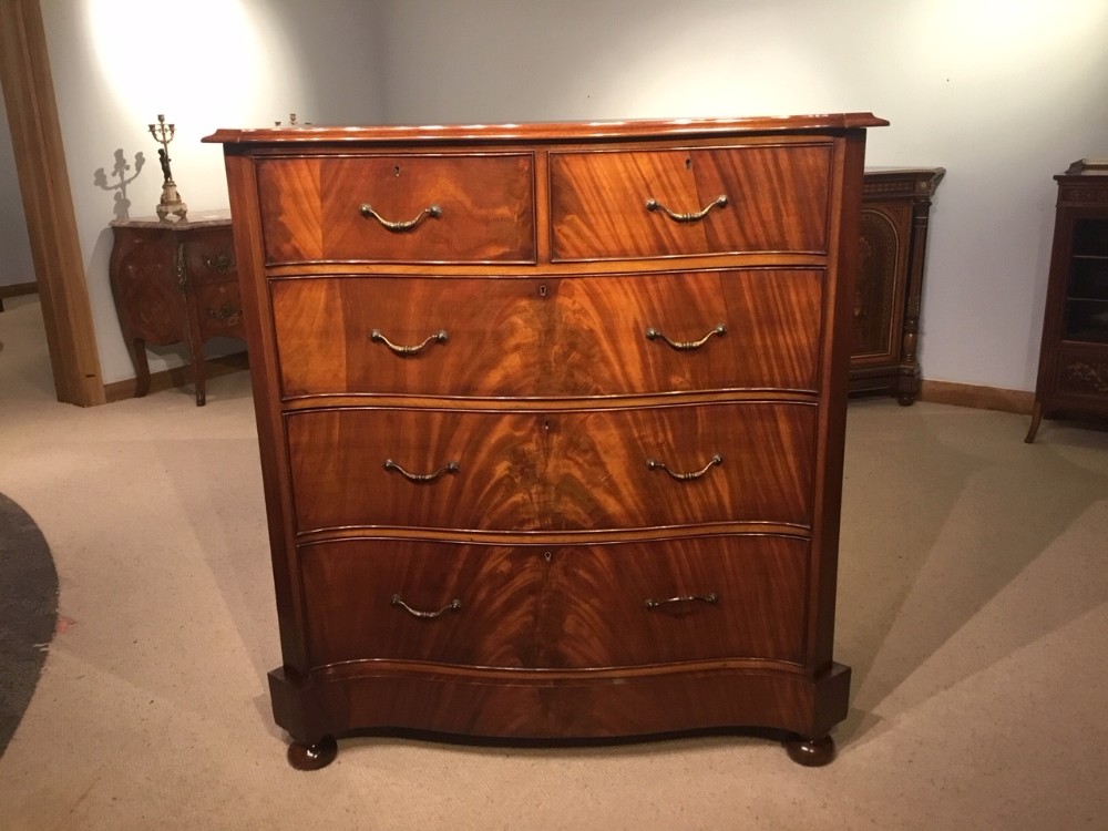 A Flamed Mahogany Edwardian Period serpentine chest of drawers