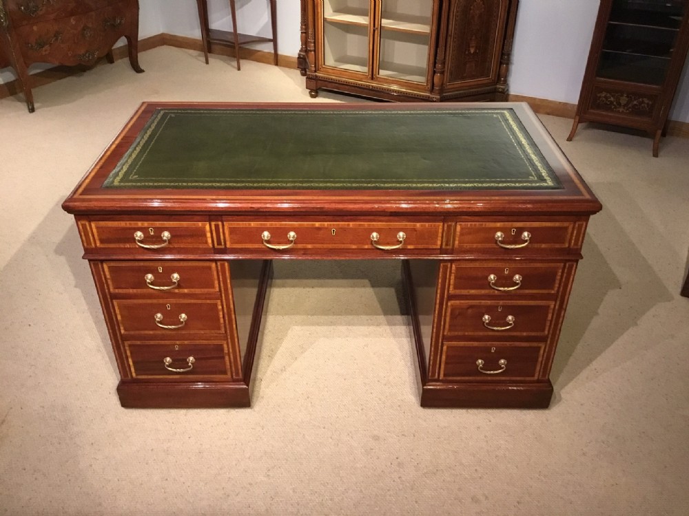 A solid mahogany and satinwood banded Edwardian Period pedestal desk