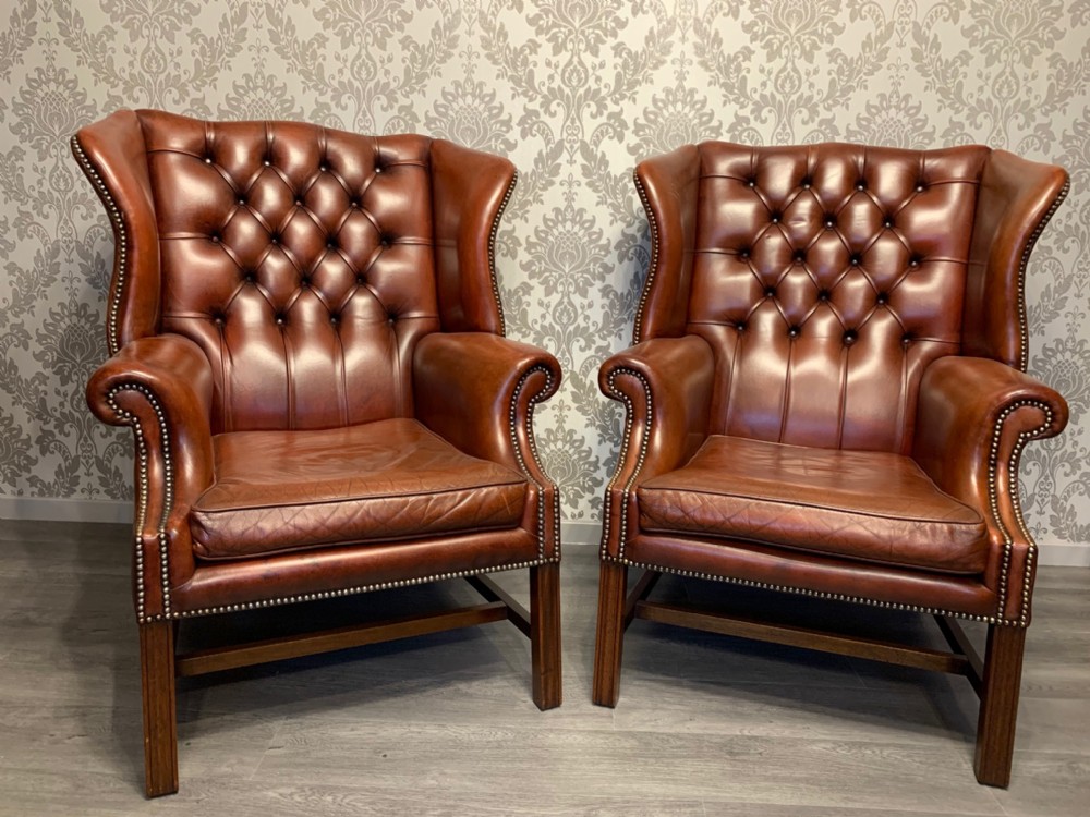 A handsome pair of Georgian style leather wing armchairs