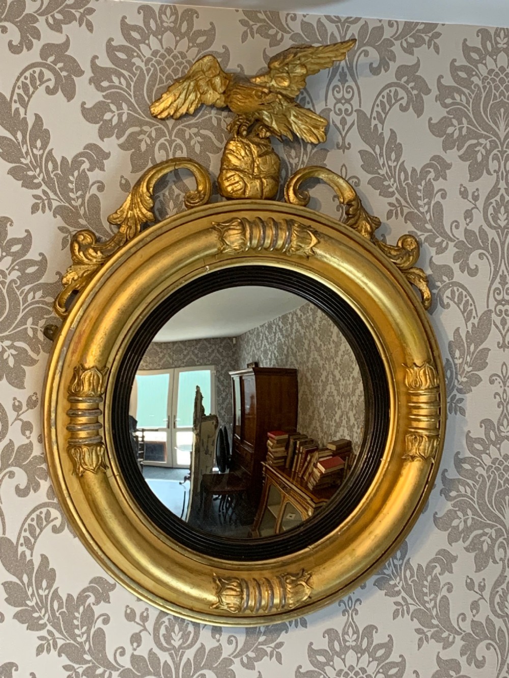 A Regency Period circular eagle gilt wood convex mirror