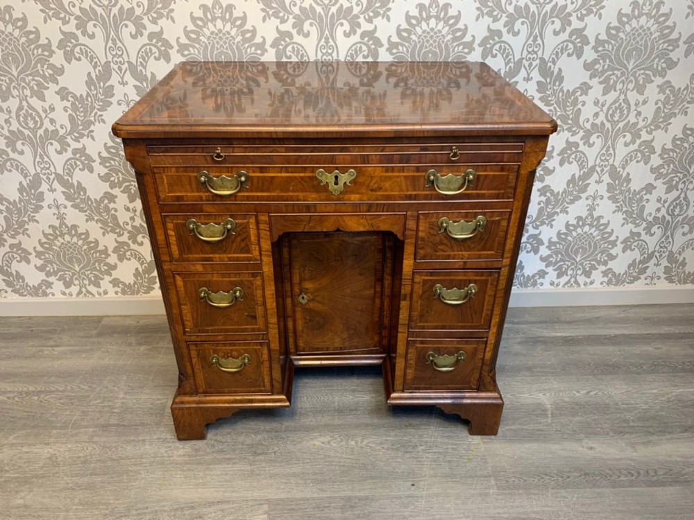 A George II Period walnut and herringbone banded knee hole desk