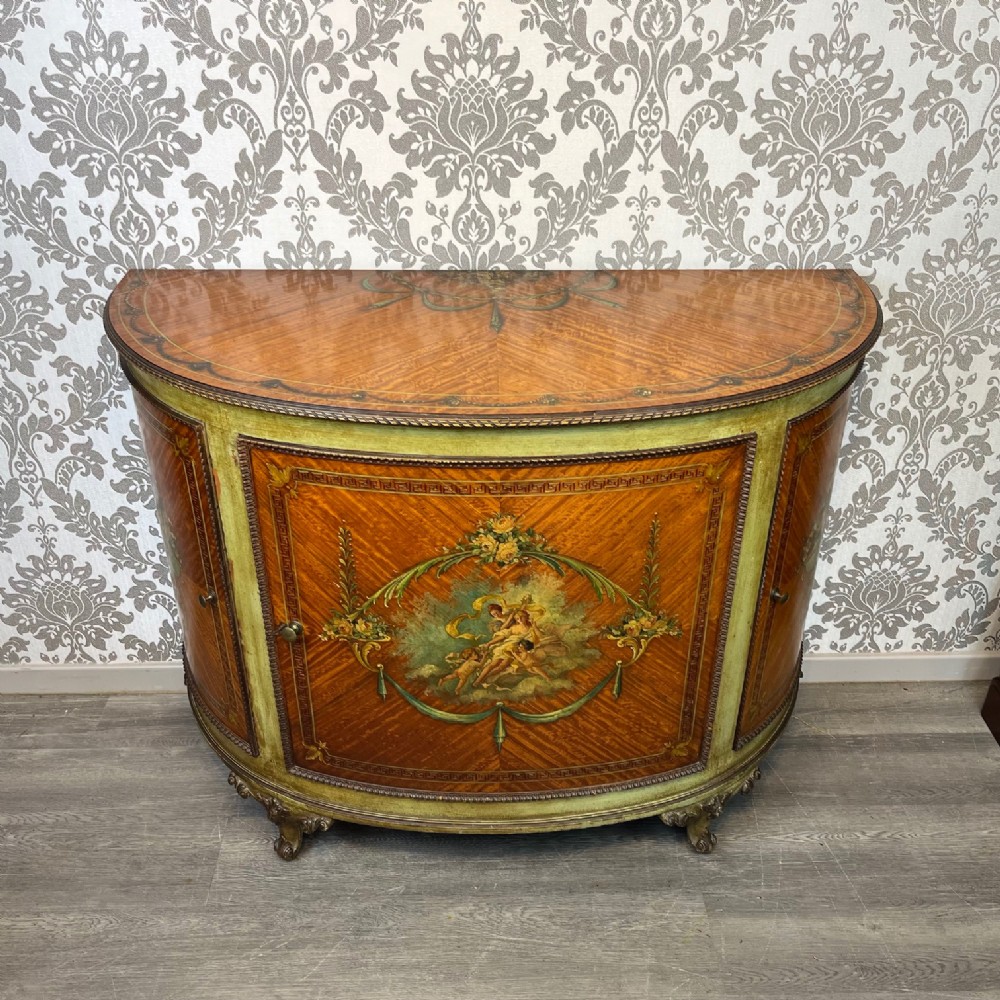 An Edwardian Period Sheraton Revival satinwood painted Demi lune cabinet.