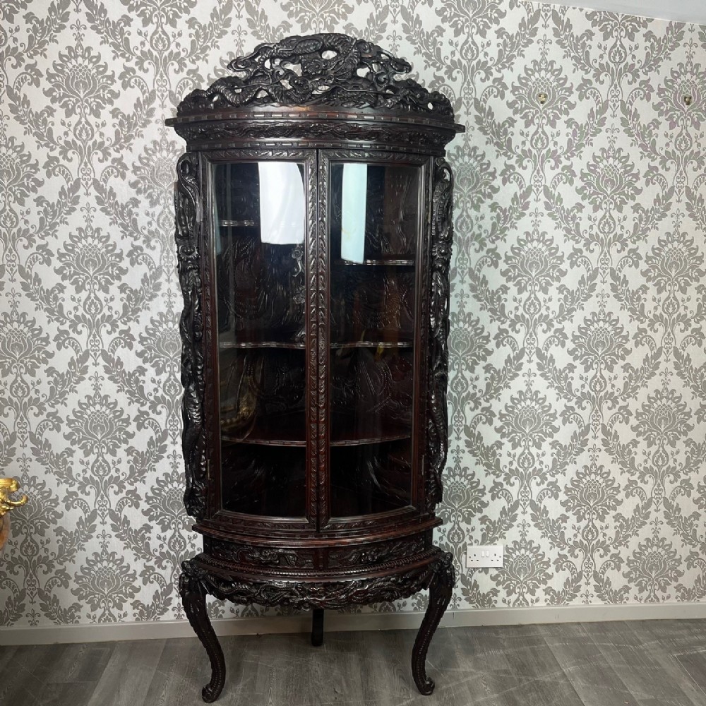 A Japanese Meiji period carved and lacquered corner cabinet