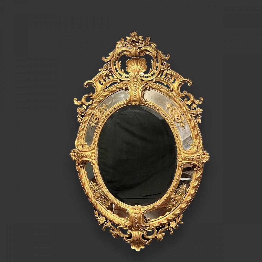 A fantastic quality large scale oval French carved gilt wood wall mirror