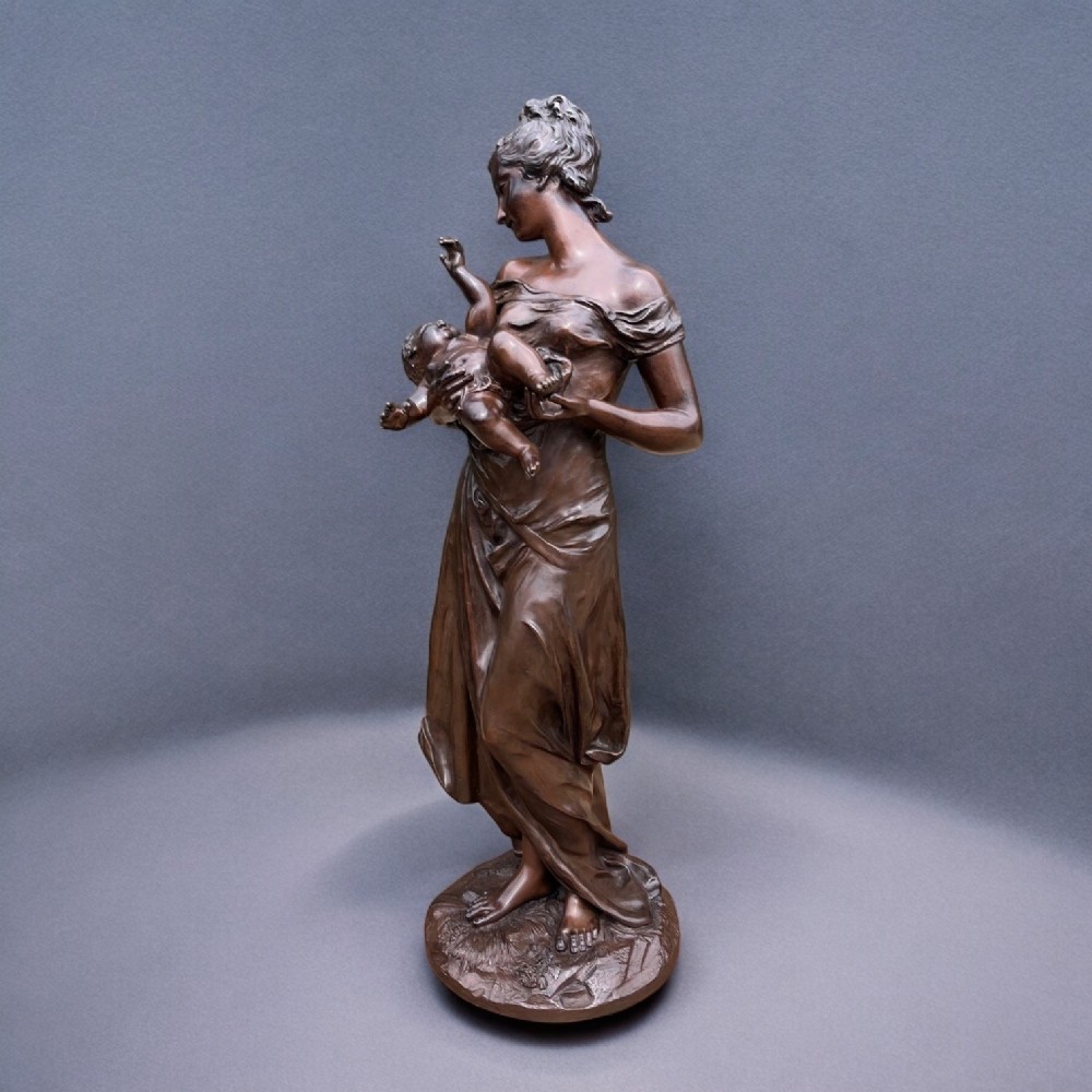 A finely cast bronze figure depicting a mother with cherub