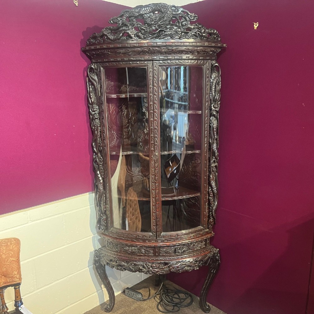 A Japanese Meiji period carved and lacquered corner cabinet