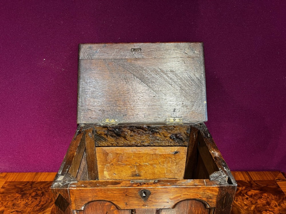 A late eighteenth-century miniature oak coffer with carved arched front panels, a kite-shaped inlay escutcheon, and a shaped apron base. View IV