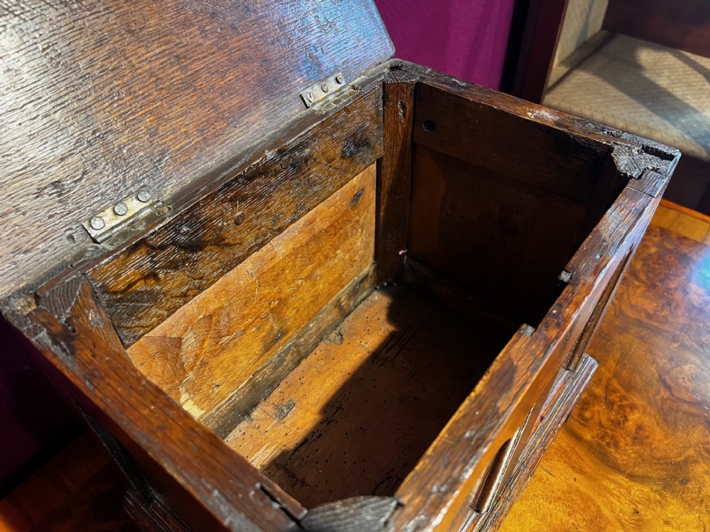 A late eighteenth-century miniature oak coffer with carved arched front panels, a kite-shaped inlay escutcheon, and a shaped apron base. View V