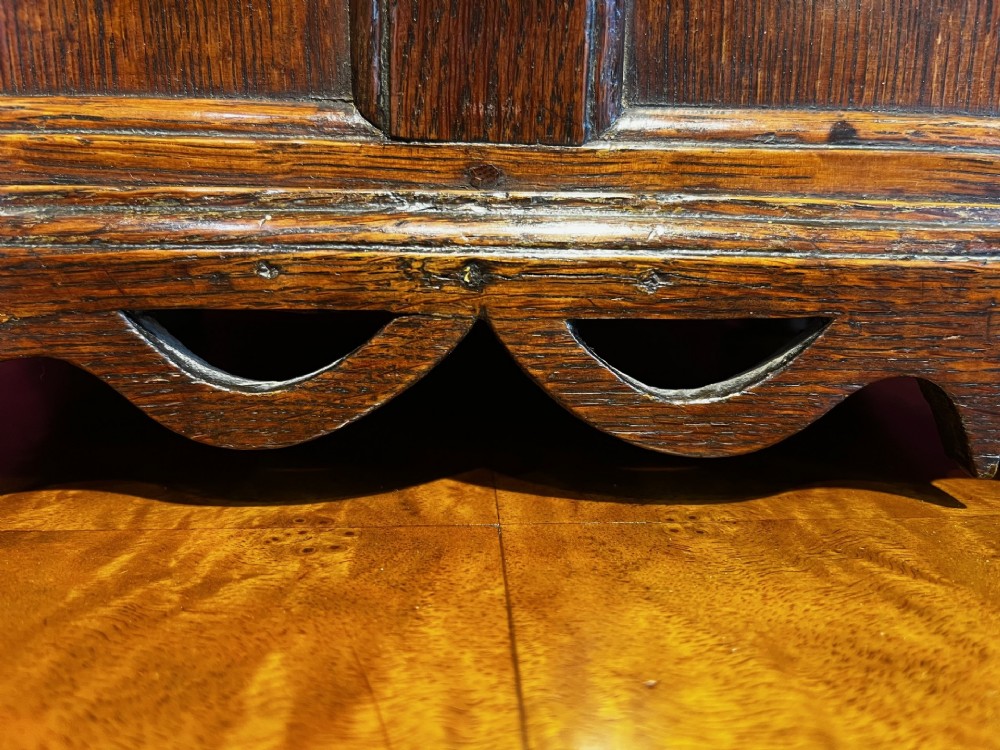 A late eighteenth-century miniature oak coffer with carved arched front panels, a kite-shaped inlay escutcheon, and a shaped apron base. View VII