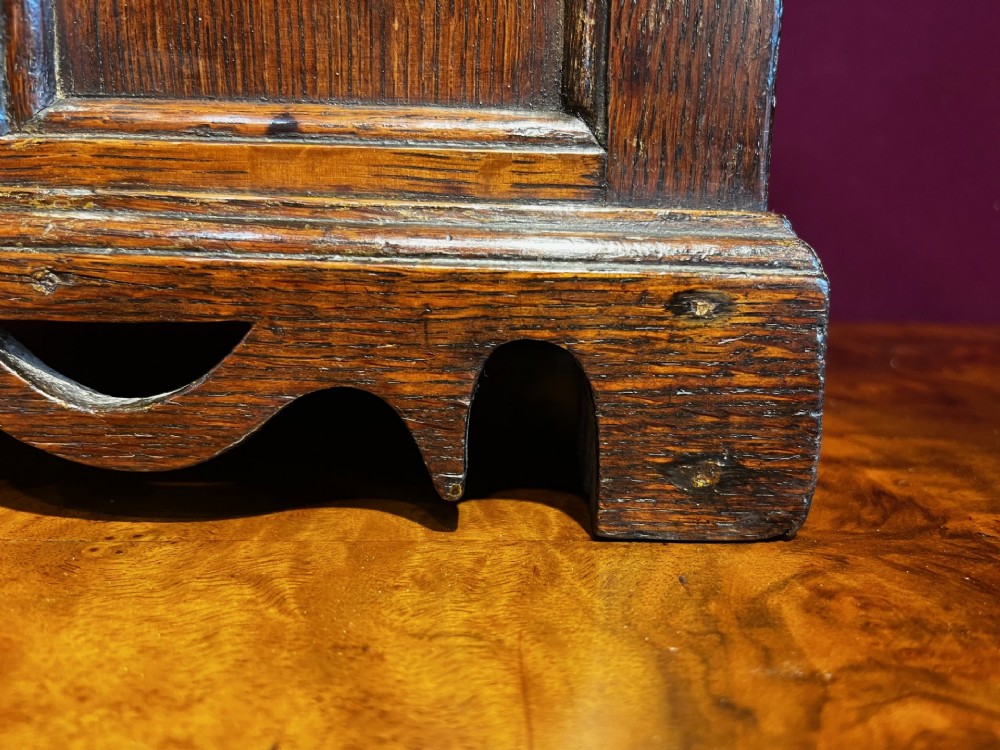 A late eighteenth-century miniature oak coffer with carved arched front panels, a kite-shaped inlay escutcheon, and a shaped apron base. View VIII