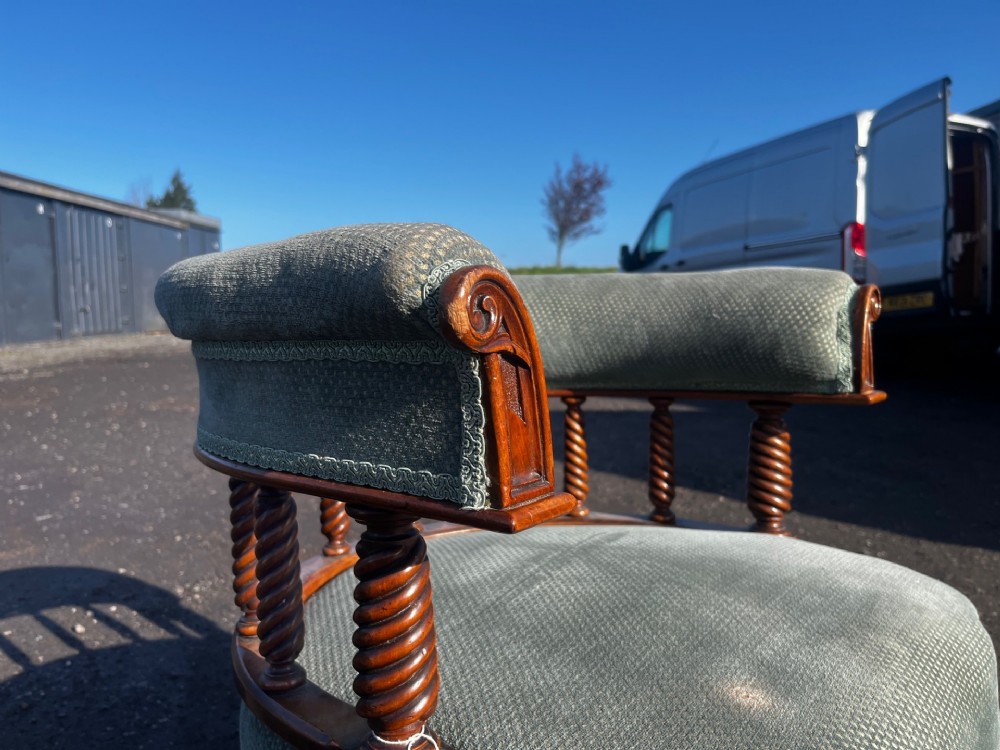 An antique Victorian walnut desk chair featuring a curved padded backrest, spiral-turned spindles, pale green textured upholstered seat, and turned legs on brass castors. View IV
