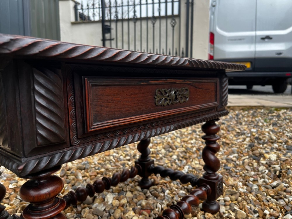 An early 19th-century Portuguese dark rosewood low table featuring spiral barley twist legs, carved rope moulding, and a single drawer with a brass keyhole escutcheon. View IV