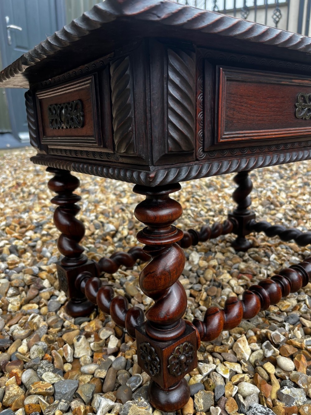 An early 19th-century Portuguese dark rosewood low table featuring spiral barley twist legs, carved rope moulding, and a single drawer with a brass keyhole escutcheon. View V