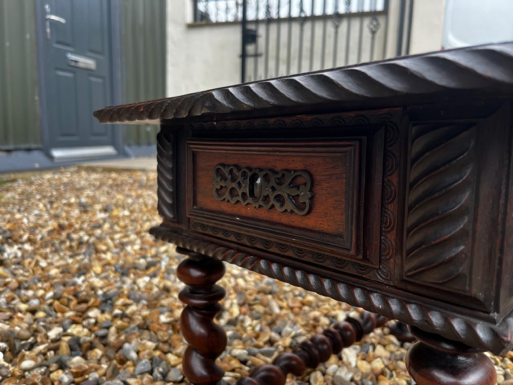 An early 19th-century Portuguese dark rosewood low table featuring spiral barley twist legs, carved rope moulding, and a single drawer with a brass keyhole escutcheon. View VI