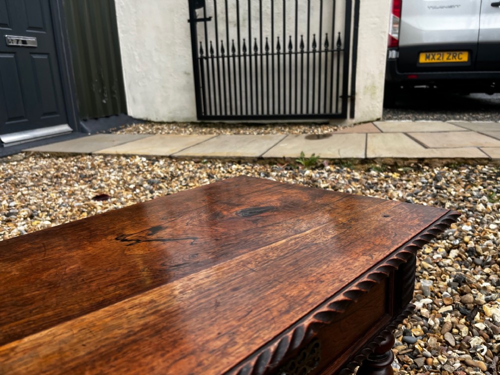 An early 19th-century Portuguese dark rosewood low table featuring spiral barley twist legs, carved rope moulding, and a single drawer with a brass keyhole escutcheon. View X