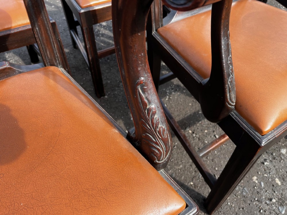 A set of late nineteenth-century mahogany Chippendale style dining chairs featuring intricately carved back splats and tan leather upholstered seats. View III