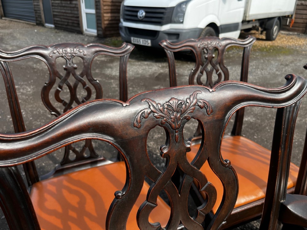 A set of late nineteenth-century mahogany Chippendale style dining chairs featuring intricately carved back splats and tan leather upholstered seats. View IV