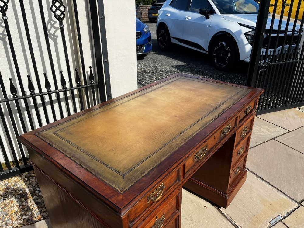 A late 19th-century mahogany pedestal desk featuring nine drawers with brass handles and a plinth base. View III