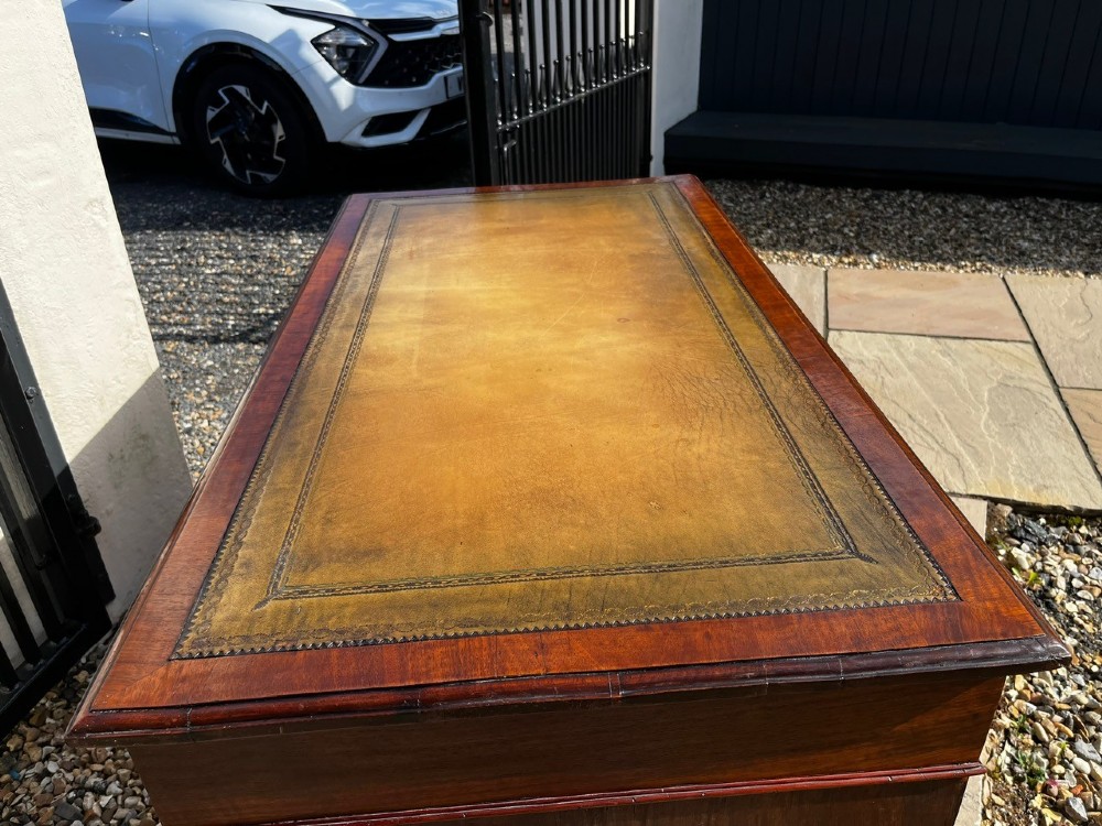 A late 19th-century mahogany pedestal desk featuring nine drawers with brass handles and a plinth base. View IV