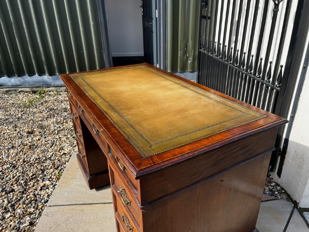 A late 19th-century mahogany pedestal desk featuring nine drawers with brass handles and a plinth base. View VI